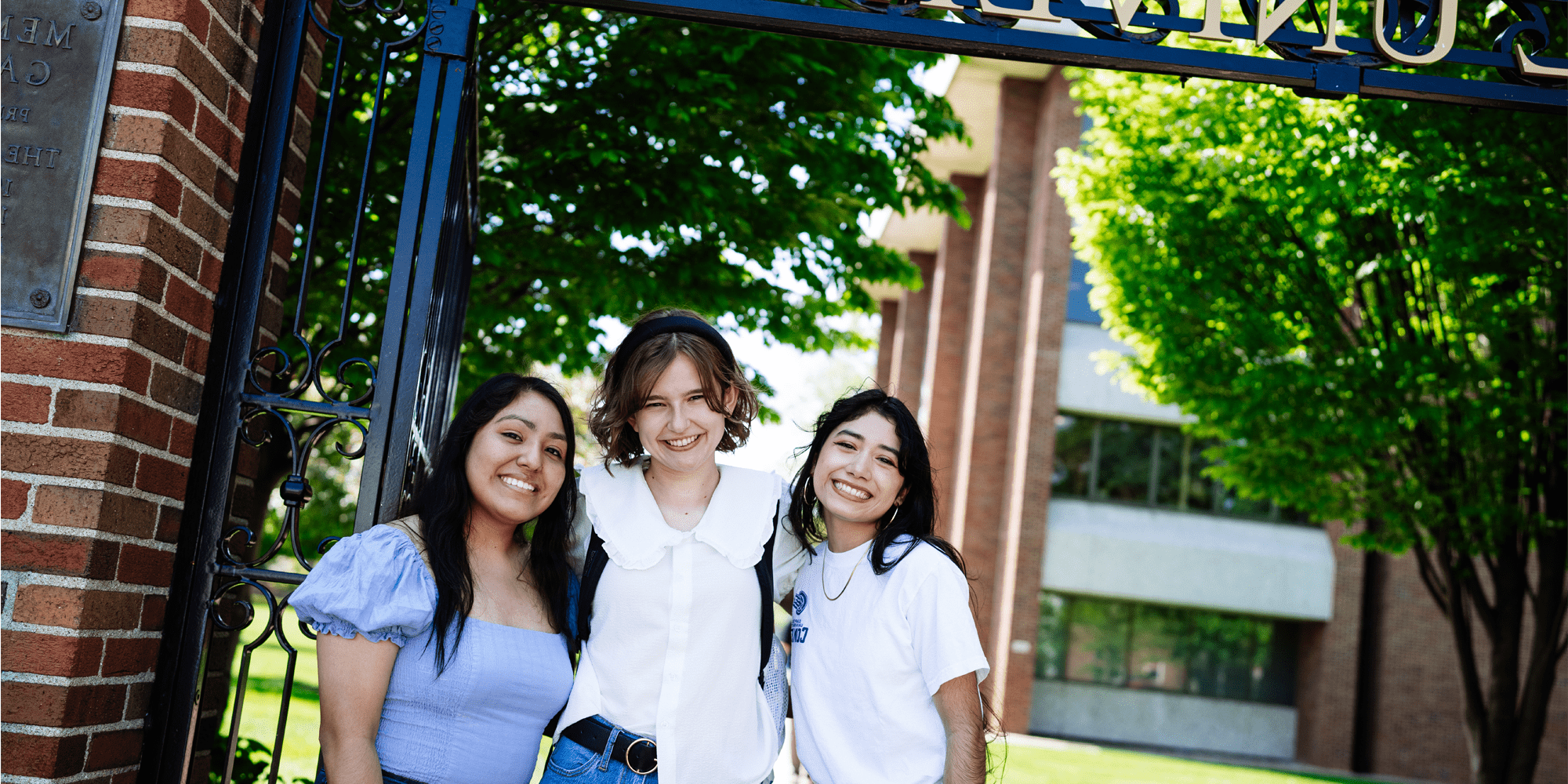 Students Posing In Front Of Gate Min